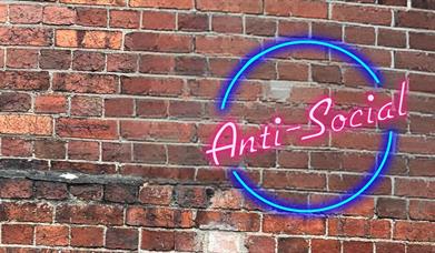Anti-Social after work drinks for everyone. Anti Social written in neon pink with a blue neon circle around it with a brick wall background