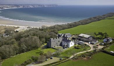 Oxwich Castle aerial view of castle with coast in background