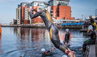 Swimmers jumping into the water ready for the start of the Swansea Triathlon