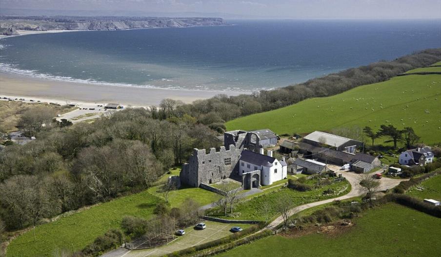 Oxwich Castle aerial view of castle with coast in background