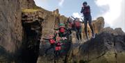 A group of people jumping into a body of water facilitated by Gower Activity Centres