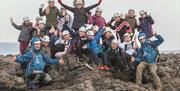 A group of people celebrating completing a hike with Gower Activity Centres