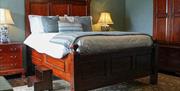 An elegant bed with half-canopy in the centre of a Georgian-themed bedroom