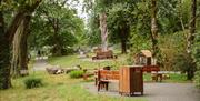 Benches and wooden sculptures in a park.