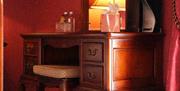 An elegant wooden dressing table with mirror and stool