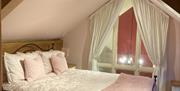 A pink themed bedroom at Gower Country Cottages