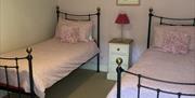 A twin bed room available in one of the Gower Country Cottages