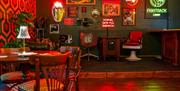 Y tu mewn i'r bar gyda llawer o arwyddion neon.