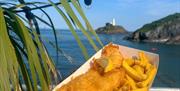 Mumbles Pier person holding fish and chips