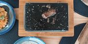 On The Rocks steak cooking on stone tableside