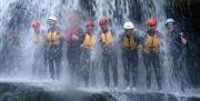 Rip N Rock group standing under waterfall