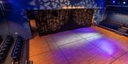 A sparse room with a stage curtain and ambient lighting.