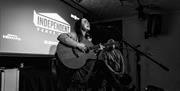 Tŷ Tawe guitarist singing on stage