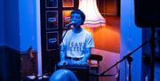 Tŷ Tawe performer on stage speaking into microphone