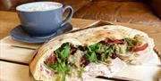 The Pizza Boys filled flatbread and cup of coffee