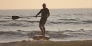 The Sup Hut paddleboarder riding a wave