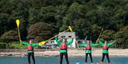 A group of people paddle boarding in Gower with Gower Activity Centres