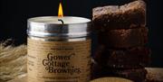 A Gower Cottage Brownie Candle next to a stack of brownies