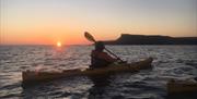 A kayaking session taking place at sunset